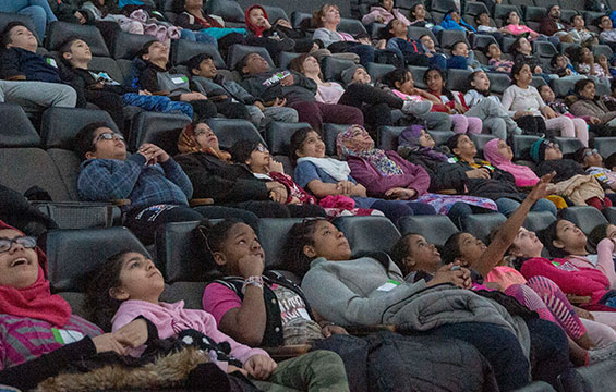 Un groupe d'élèves assis dans le cinéma OMNIMAX.