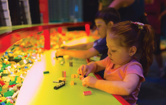 Kids build with Lego bricks at a table.