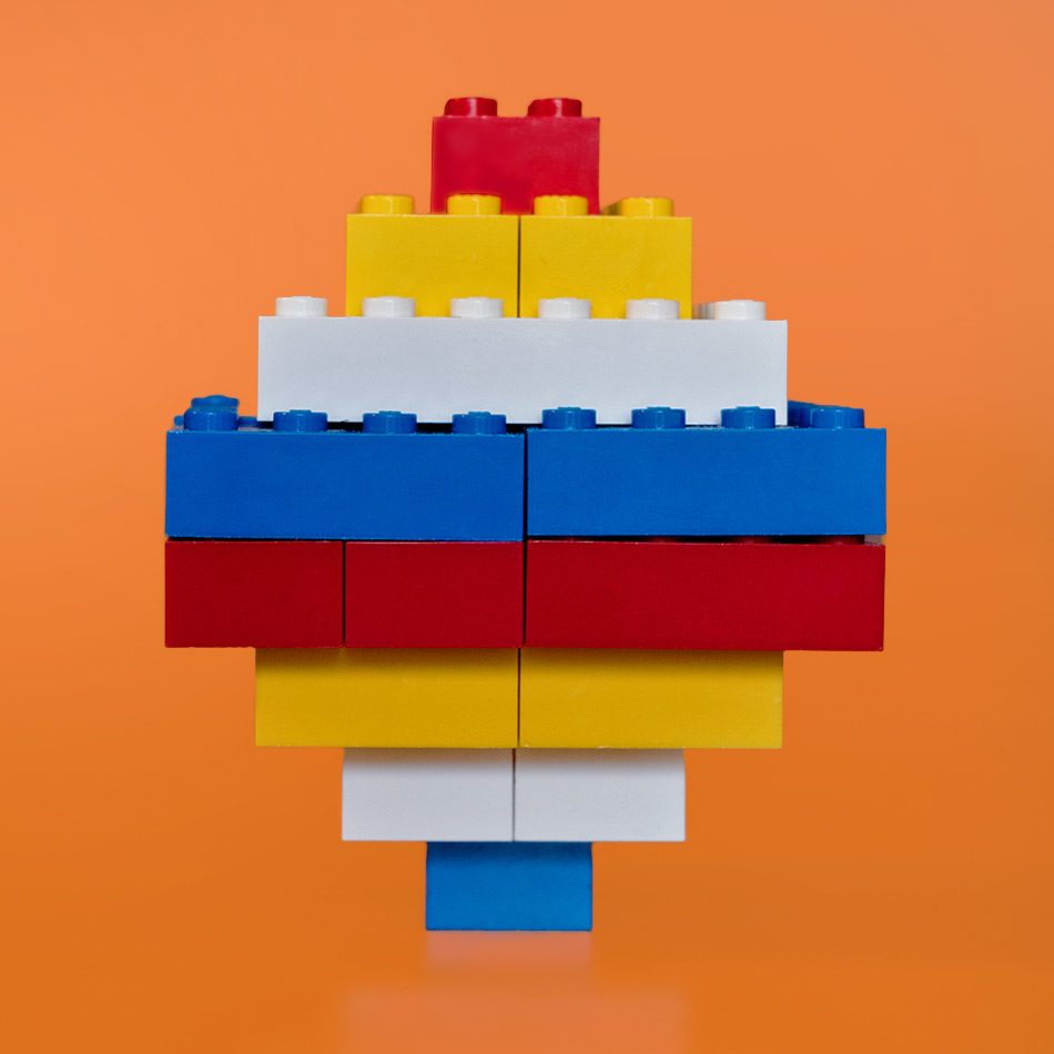 Deux pyramides multicolores en LEGO assemblées base contre base.