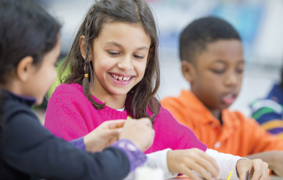 Des enfants souriants bricolent ensemble.